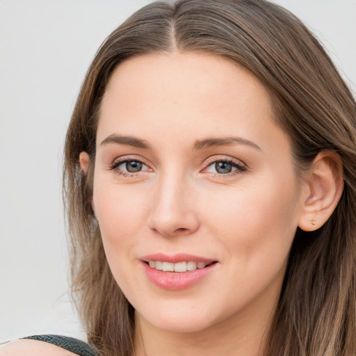 Joyful white young-adult female with long  brown hair and blue eyes