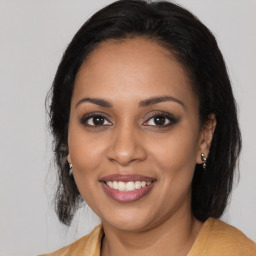 Joyful black young-adult female with medium  brown hair and brown eyes