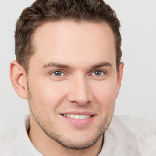 Joyful white young-adult male with short  brown hair and grey eyes