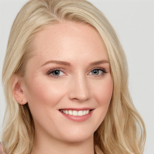 Joyful white young-adult female with long  blond hair and blue eyes