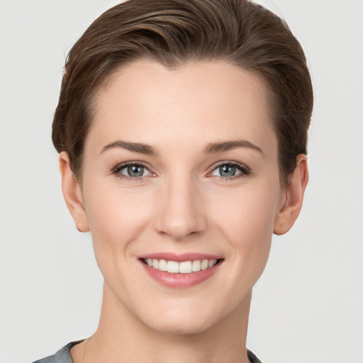 Joyful white young-adult female with short  brown hair and grey eyes