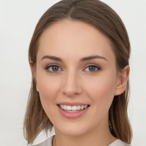 Joyful white young-adult female with long  brown hair and grey eyes