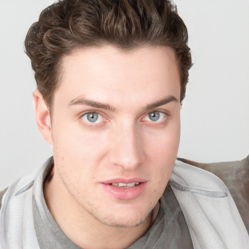 Joyful white young-adult male with short  brown hair and blue eyes