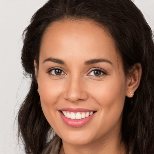 Joyful white young-adult female with long  brown hair and brown eyes