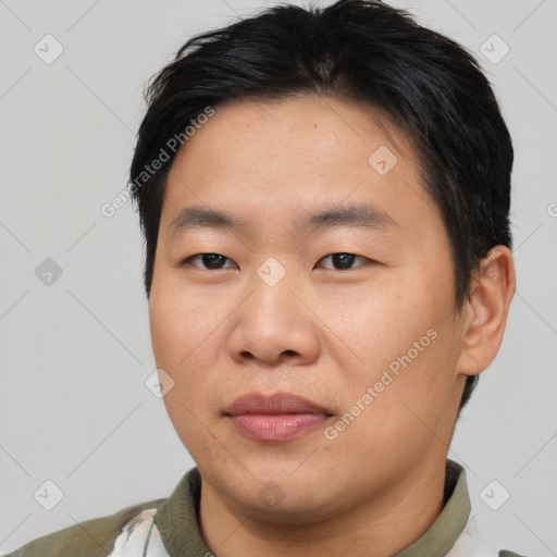 Joyful asian young-adult male with short  brown hair and brown eyes