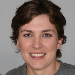 Joyful white young-adult female with medium  brown hair and blue eyes