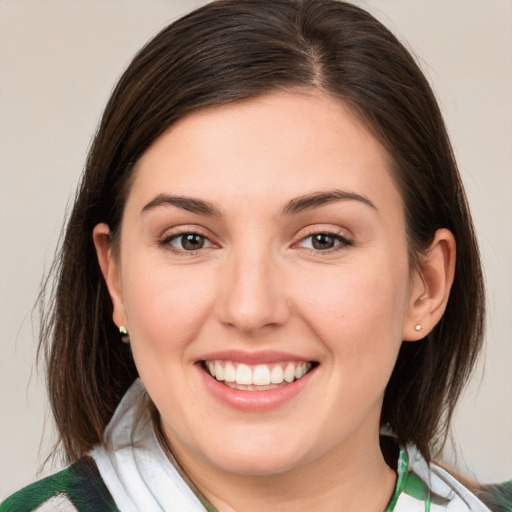 Joyful white young-adult female with medium  brown hair and green eyes