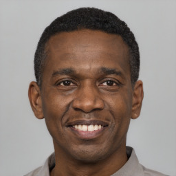 Joyful black young-adult male with short  black hair and brown eyes