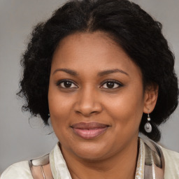 Joyful black adult female with medium  brown hair and brown eyes