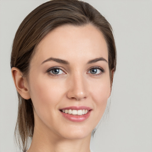 Joyful white young-adult female with medium  brown hair and grey eyes