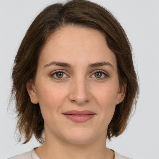 Joyful white young-adult female with medium  brown hair and green eyes