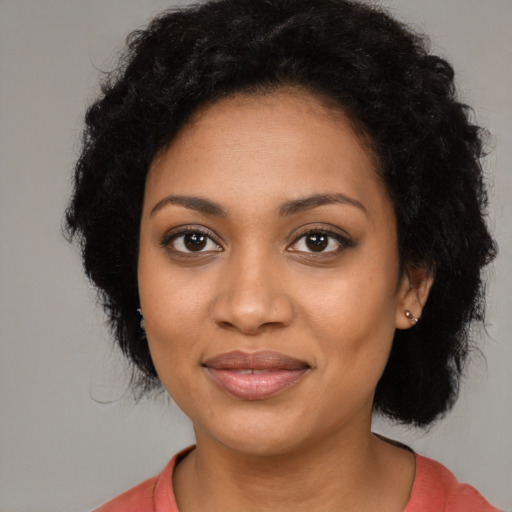 Joyful black young-adult female with long  black hair and brown eyes