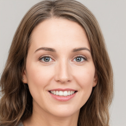 Joyful white young-adult female with long  brown hair and grey eyes