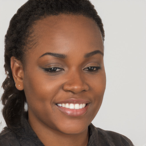 Joyful black young-adult female with long  brown hair and brown eyes