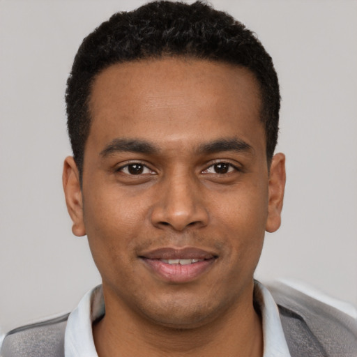 Joyful black young-adult male with short  black hair and brown eyes
