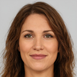 Joyful white adult female with long  brown hair and brown eyes