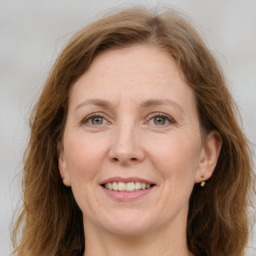 Joyful white adult female with long  brown hair and green eyes