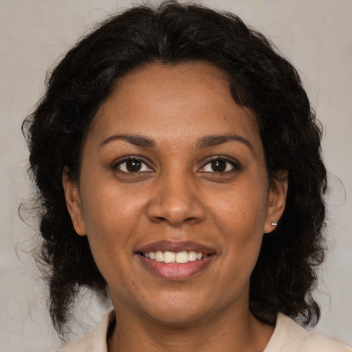 Joyful black adult female with medium  brown hair and brown eyes