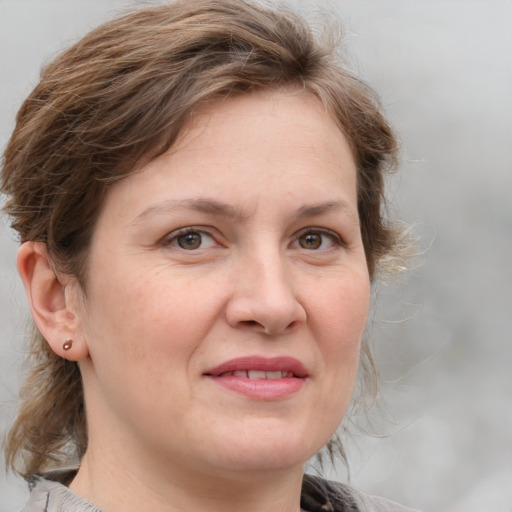 Joyful white adult female with medium  brown hair and grey eyes