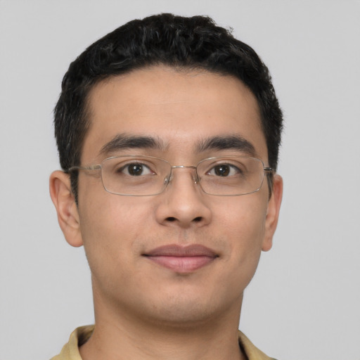 Joyful latino young-adult male with short  brown hair and brown eyes