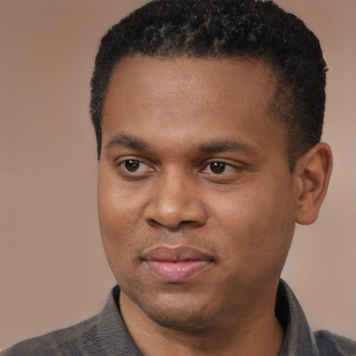 Joyful black young-adult male with short  black hair and brown eyes