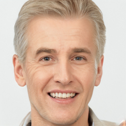 Joyful white adult male with short  blond hair and brown eyes