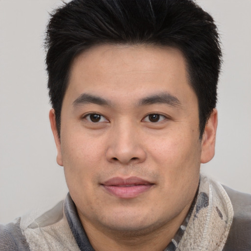 Joyful asian young-adult male with short  brown hair and brown eyes