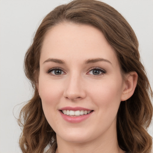 Joyful white young-adult female with long  brown hair and grey eyes