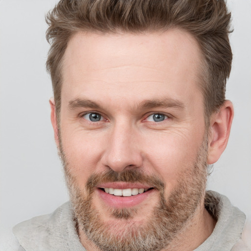 Joyful white adult male with short  brown hair and grey eyes