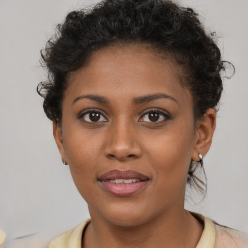 Joyful black young-adult female with short  brown hair and brown eyes