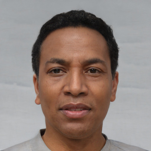Joyful black adult male with short  black hair and brown eyes