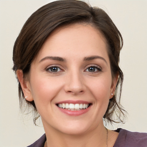 Joyful white young-adult female with medium  brown hair and grey eyes