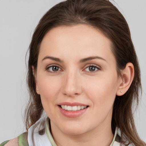 Joyful white young-adult female with medium  brown hair and grey eyes