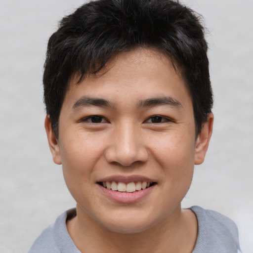 Joyful asian young-adult male with short  brown hair and brown eyes