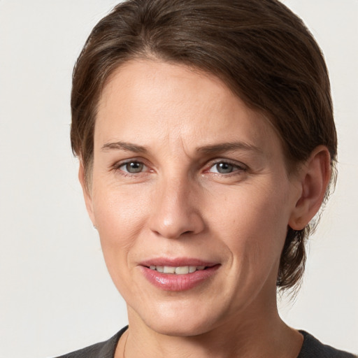 Joyful white adult female with medium  brown hair and grey eyes