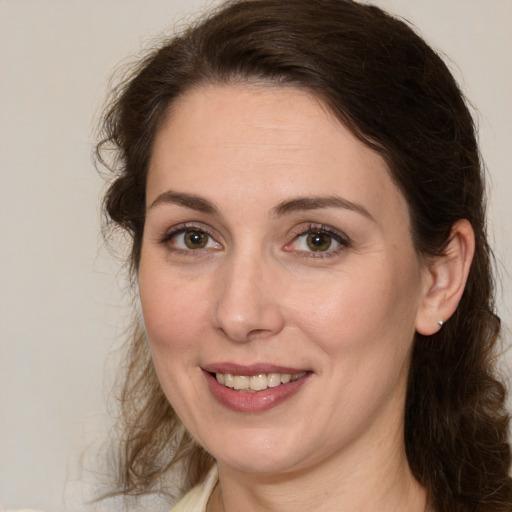 Joyful white adult female with medium  brown hair and green eyes