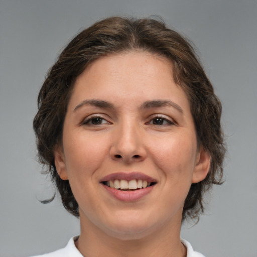 Joyful white adult female with medium  brown hair and brown eyes