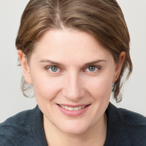 Joyful white young-adult female with medium  brown hair and grey eyes