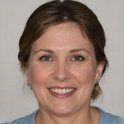 Joyful white adult female with medium  brown hair and blue eyes