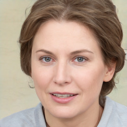 Joyful white young-adult female with medium  brown hair and blue eyes