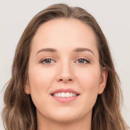 Joyful white young-adult female with long  brown hair and grey eyes