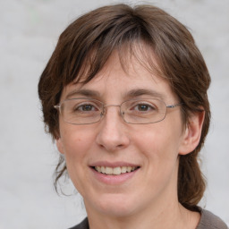 Joyful white adult female with medium  brown hair and grey eyes