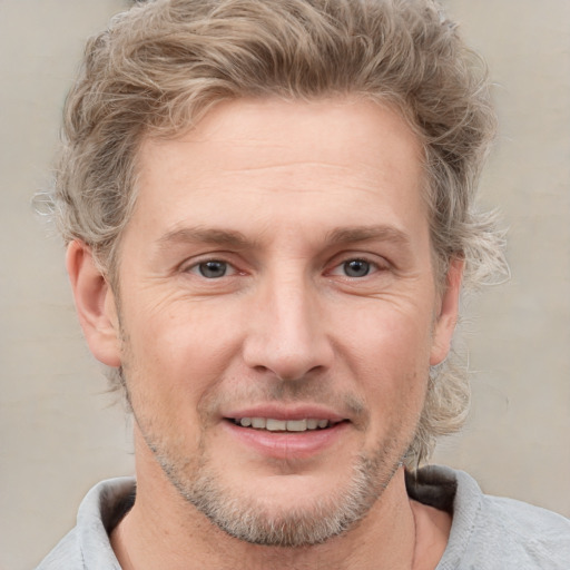 Joyful white adult male with short  brown hair and grey eyes