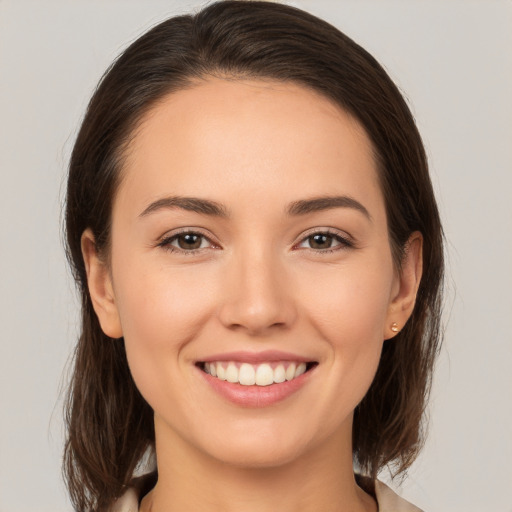 Joyful white young-adult female with medium  brown hair and brown eyes