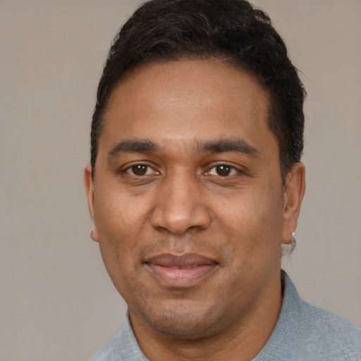 Joyful black adult male with short  black hair and brown eyes