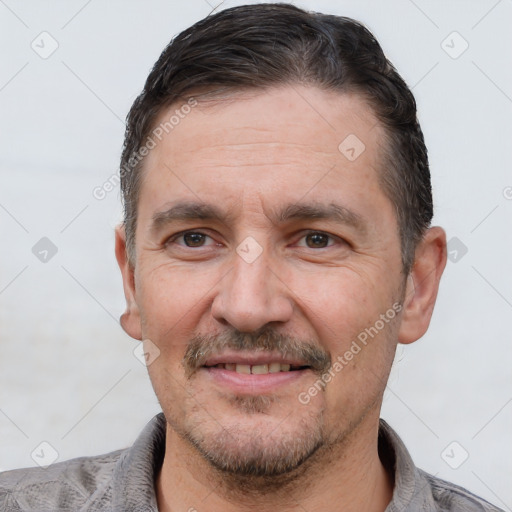 Joyful white adult male with short  black hair and brown eyes