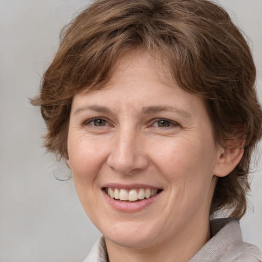 Joyful white adult female with medium  brown hair and grey eyes