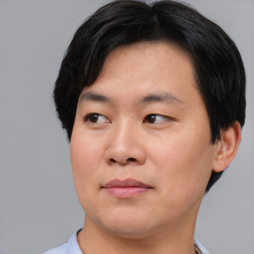 Joyful asian young-adult male with short  black hair and brown eyes