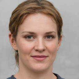 Joyful white young-adult female with medium  brown hair and blue eyes