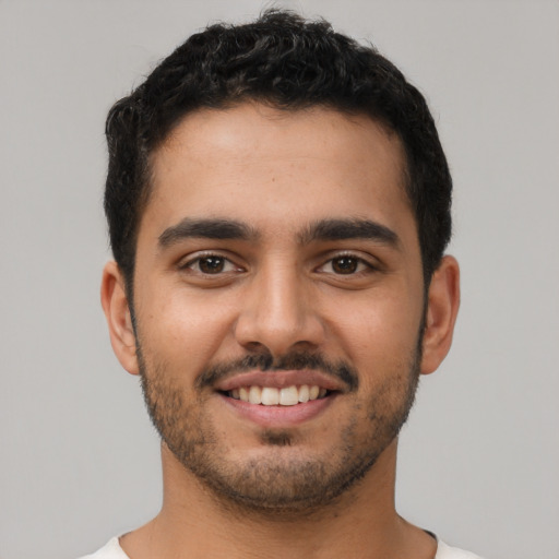 Joyful latino young-adult male with short  brown hair and brown eyes